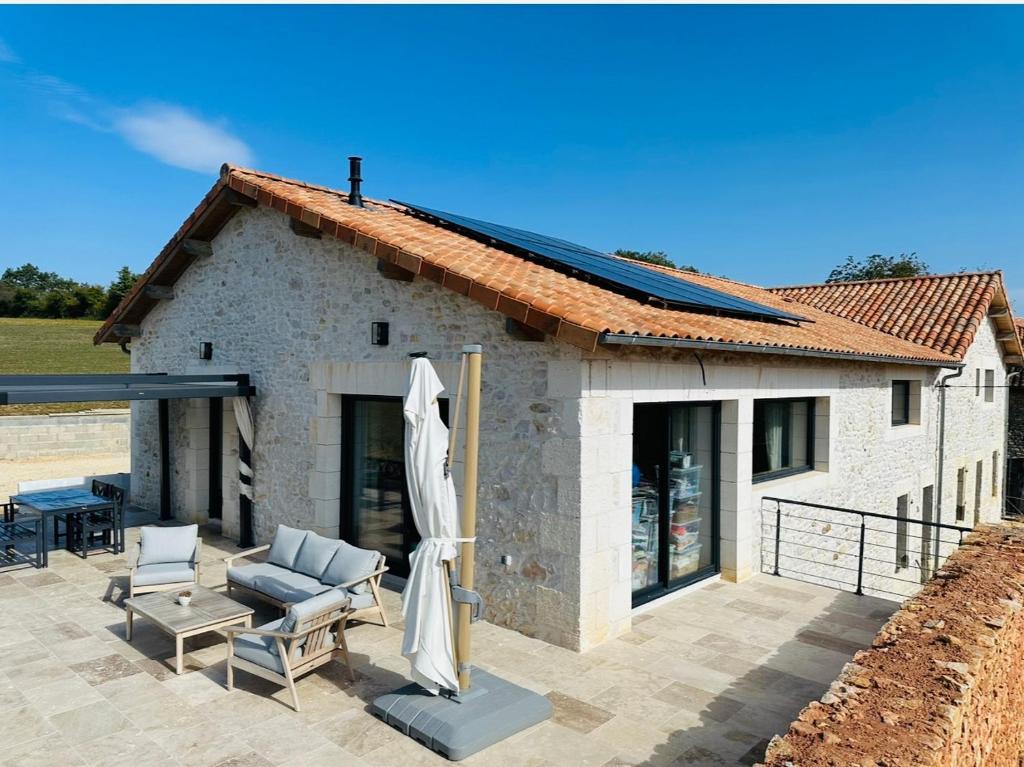 Cette maison en pierre dispose d'une terrasse et d'un toit. dans l'établissement Maison de campagne idéale pour les retrouvailles en famille, à Varaignes