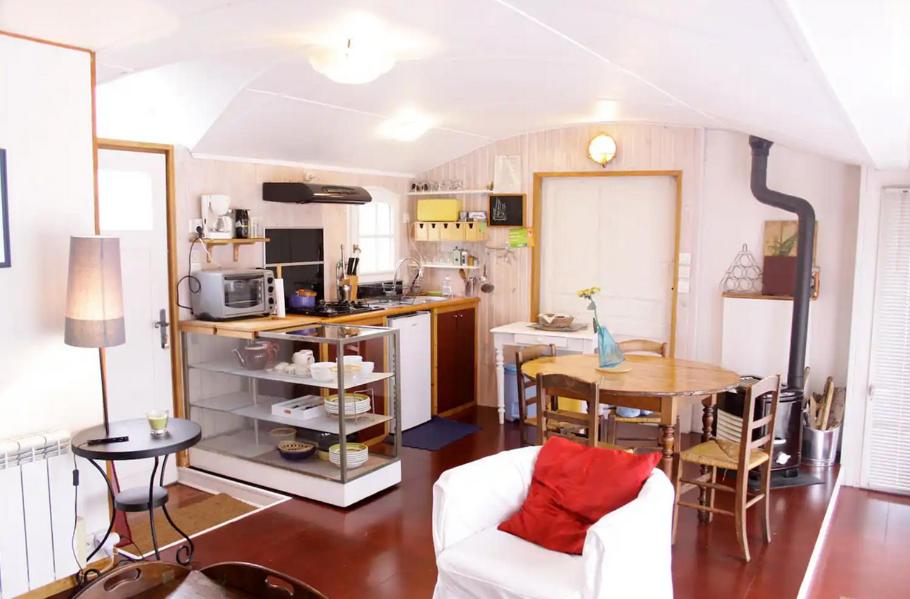 a living room with a table and a kitchen at Charmante Péniche - Séjour atypique Nantes in Nantes