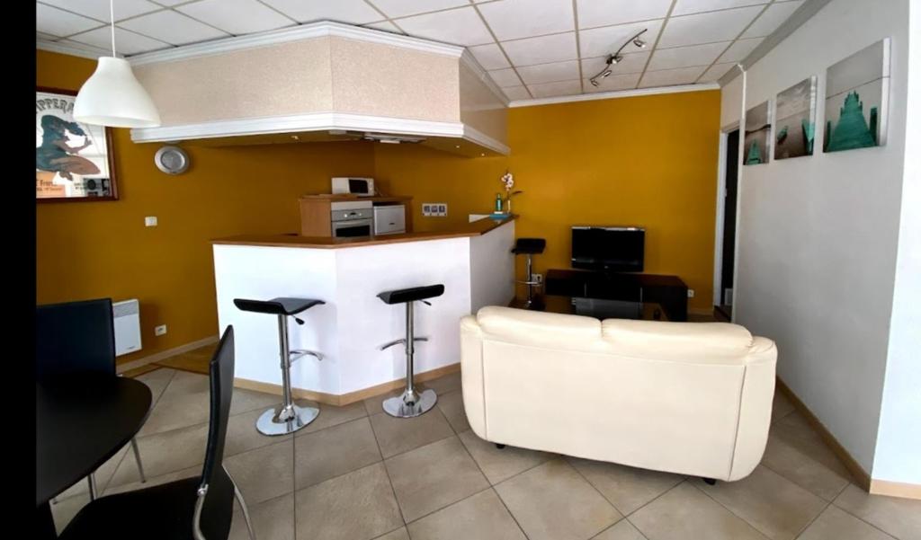 un salon de coiffure avec un comptoir et des tabourets dans une pièce dans l'établissement La source, à Pornic