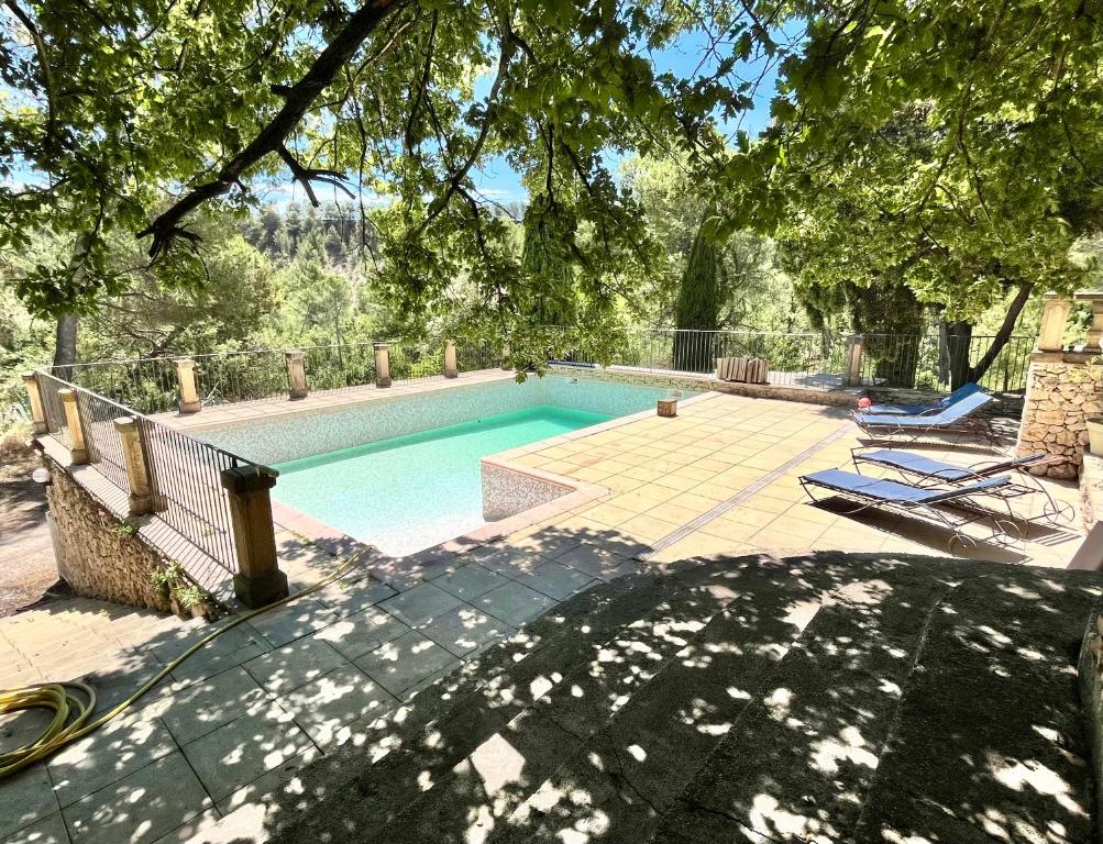 - une piscine avec 2 chaises longues dans la cour dans l'établissement Bastide provençale familiale, grande piscine, prés d'Aix en pleine nature, à Bouc-Bel-Air