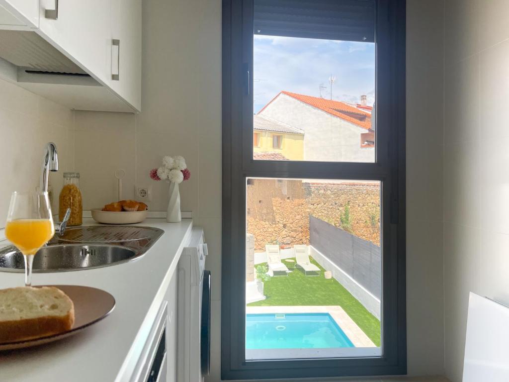a kitchen with a view of a swimming pool through a window at CerezasHomes5 in Jaraiz de la Vera