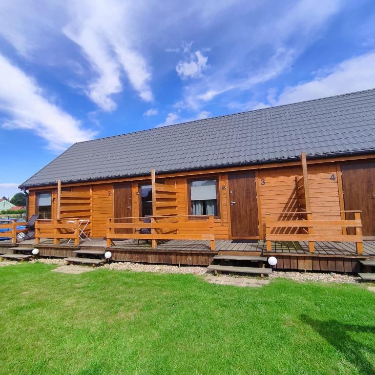 a large wooden cabin with a large yard at Apartamenty Cztery Siostry in Zastań