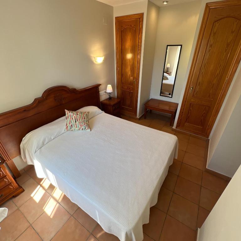 a bedroom with a white bed and a mirror at Villas Monte Jávea - BTB in Jávea