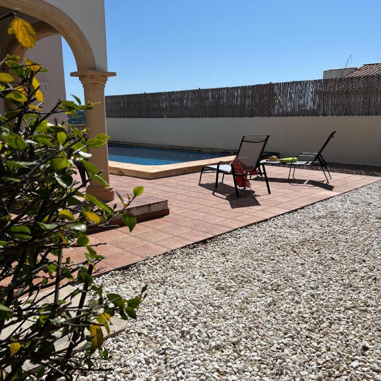 a patio with two chairs and a swimming pool at Villas Monte Jávea - BTB in Jávea