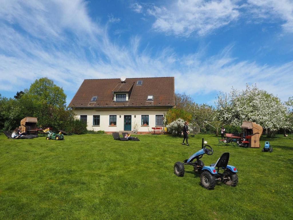 a house with a tractor parked in the grass at Ferienhof Hafflandsichten in Dargen