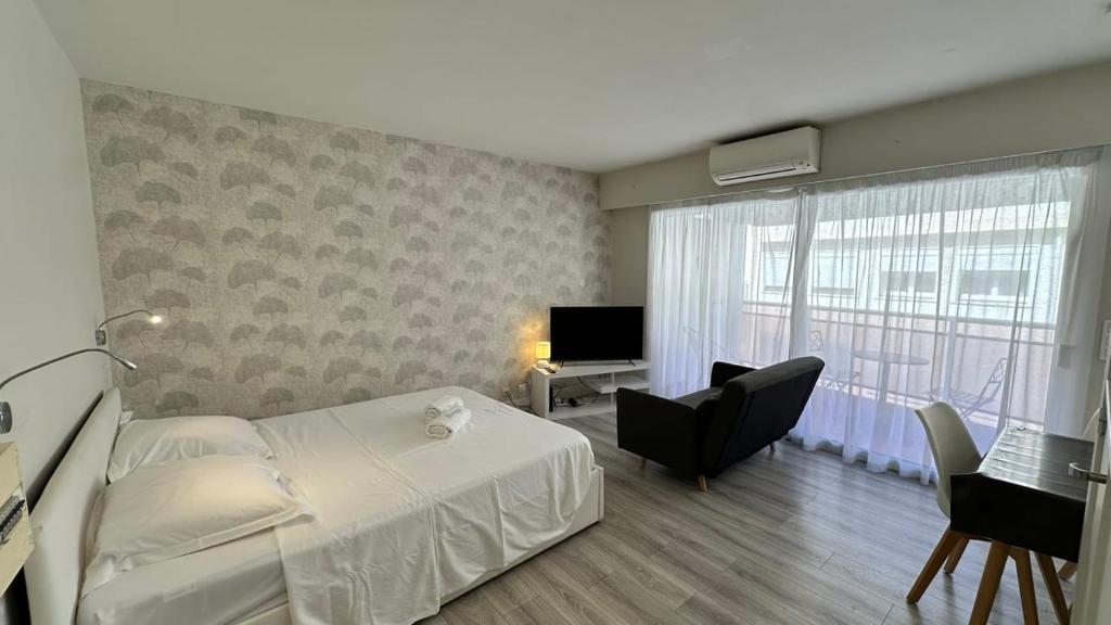 une chambre avec un lit, un bureau et une télévision dans l'établissement B057-Beau studio Carré D'Or & Proche de la Mer Cannes, à Cannes