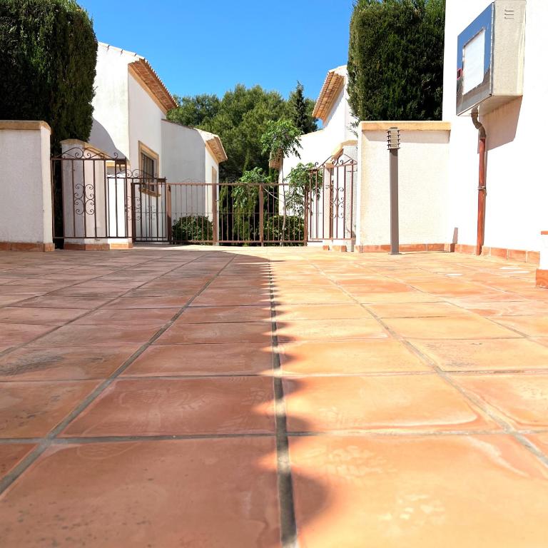 an empty courtyard with a fence and trees at Villas Monte Jávea - BTB in Jávea