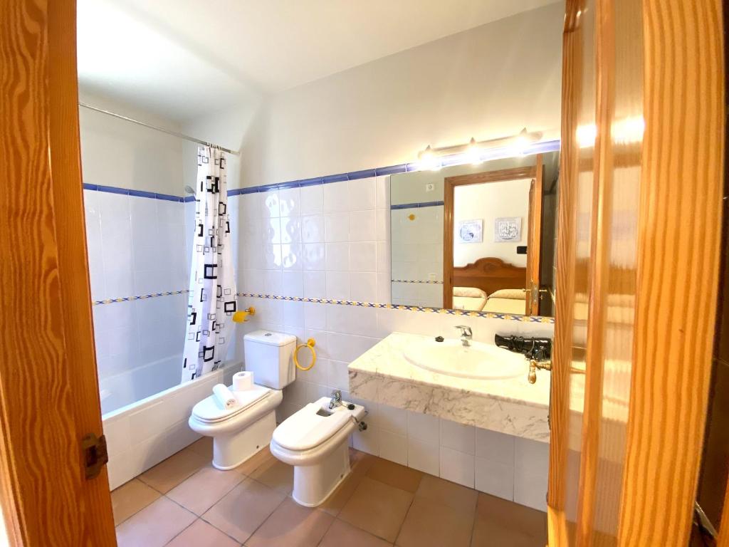 a bathroom with two toilets and a sink and a mirror at Villas Monte Jávea - BTB in Jávea