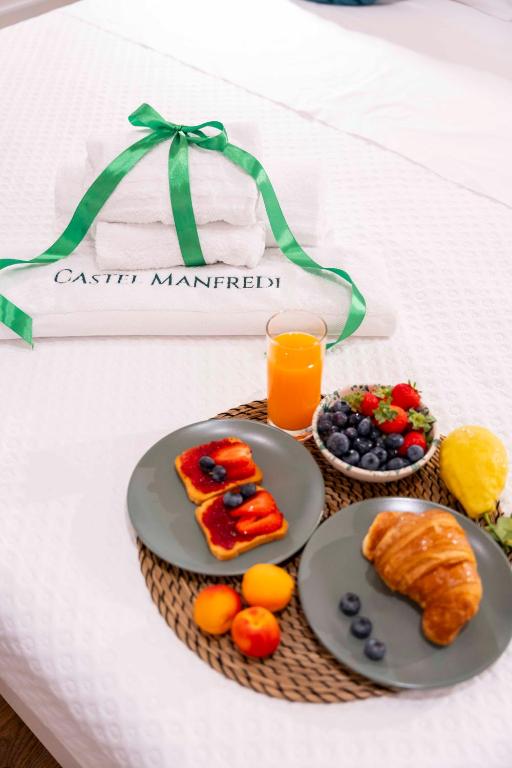 a tray of breakfast foods and a glass of orange juice at Castel Manfredi Apartments in Manfredonia