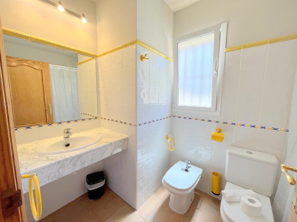 a bathroom with a sink and a toilet and a window at Villas Monte Jávea - BTB in Jávea
