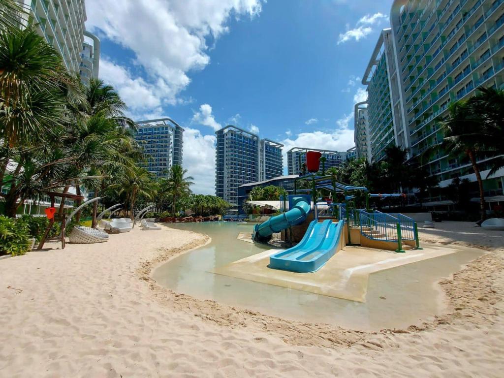 een speeltuin met een glijbaan op een strand bij MicasaAzure77 in Manilla