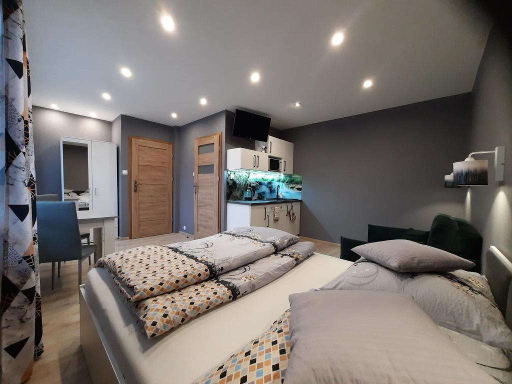 a bedroom with two beds and a kitchen with a fishtank at Apartamenty Pokoje Lawenda Wisła in Wisła