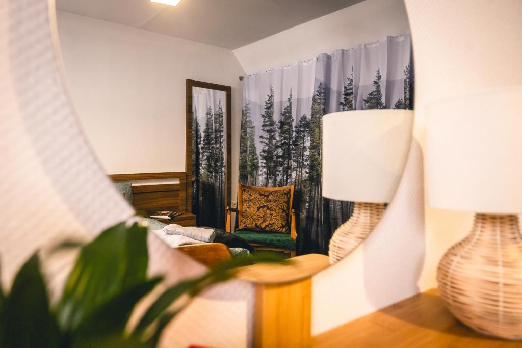 a living room with a chair and a lamp at Villa Papírkutya in Veszprém