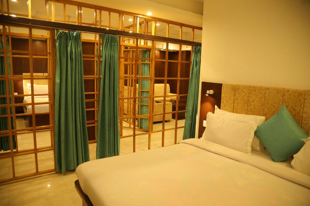 Postel nebo postele na pokoji v ubytování Hotel Ganga Aatitheyam