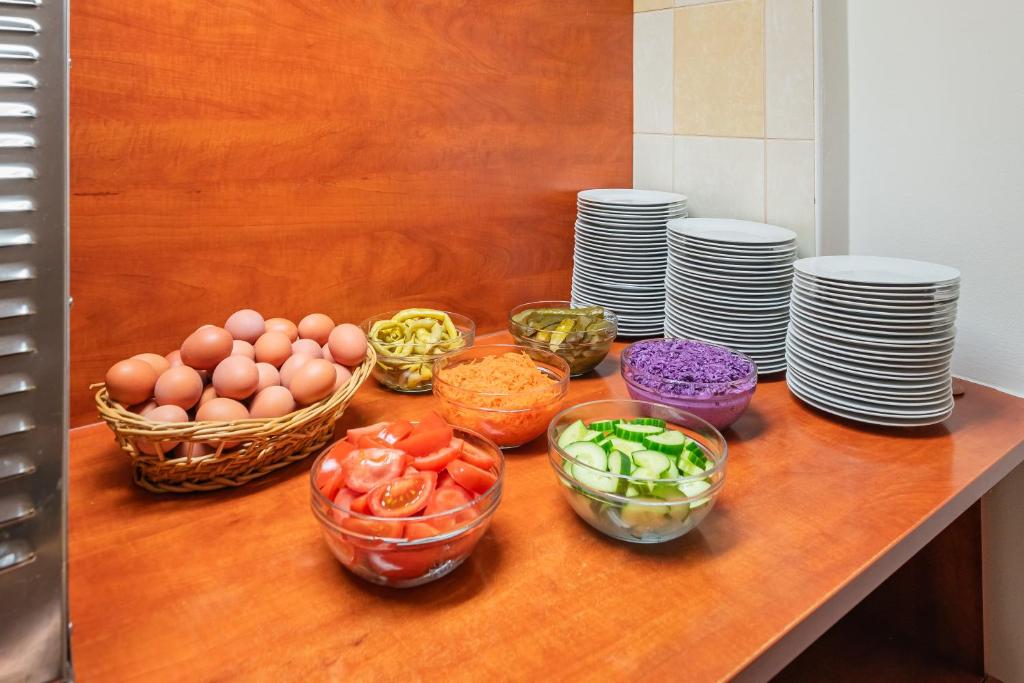 a table topped with bowls of vegetables and plates at City Central De Luxe in Prague