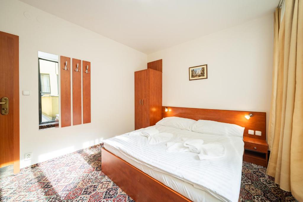 a bedroom with a bed with white sheets and a mirror at City Central De Luxe in Prague