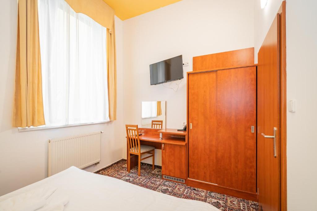a hotel room with a desk and a cabinet at City Central De Luxe in Prague