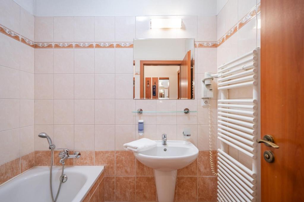 a bathroom with a sink and a bath tub at City Central De Luxe in Prague
