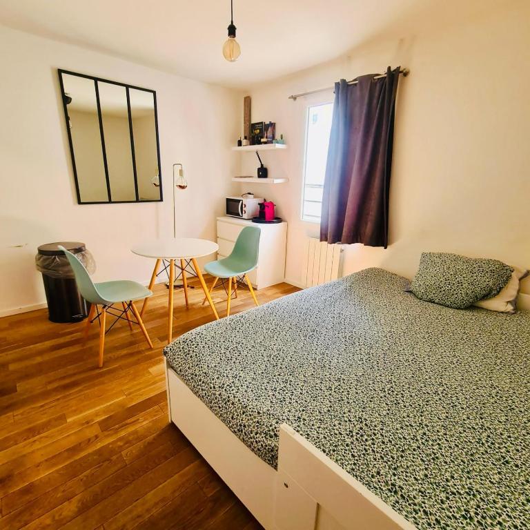 une chambre avec un lit, une table et des chaises dans l'établissement Au centre de paris Saint-michel et St germain despres, à Paris