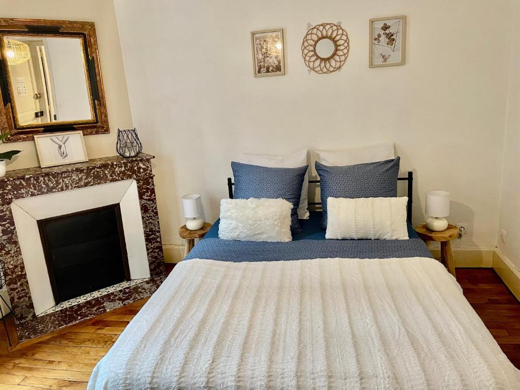 - une chambre avec un lit, une cheminée et un miroir dans l'établissement Akwaba Nancy, à Nancy