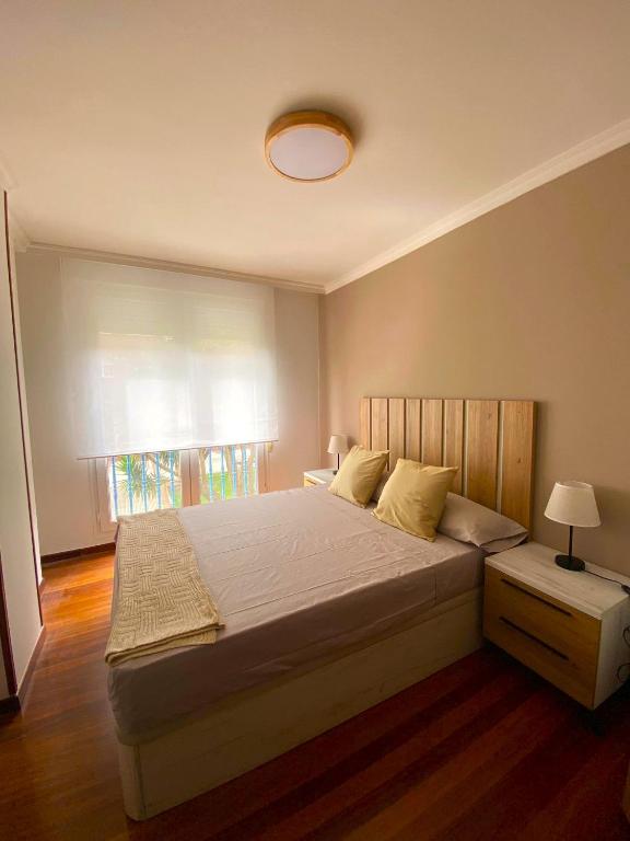 a bedroom with a large bed and a window at Apartamento nuevo en Zona Baja de Cotolino in Castro-Urdiales