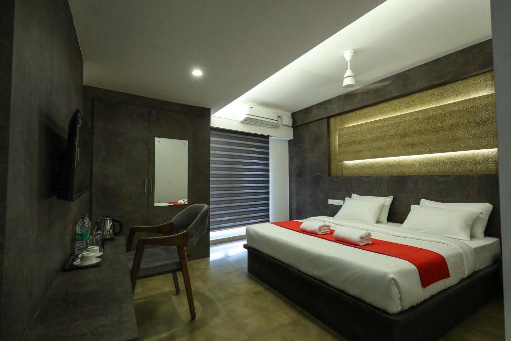 a bedroom with a large bed with a red blanket at D-Luxe Hotel in Ernakulam
