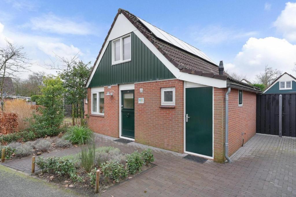 a red brick house with green garage doors at Jonkerstee 217 - Ouddorp - NOT FOR COMPANIES in Ouddorp