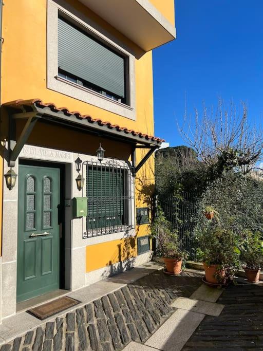 a house with a green door and some plants at Villa Marie in Betanzos