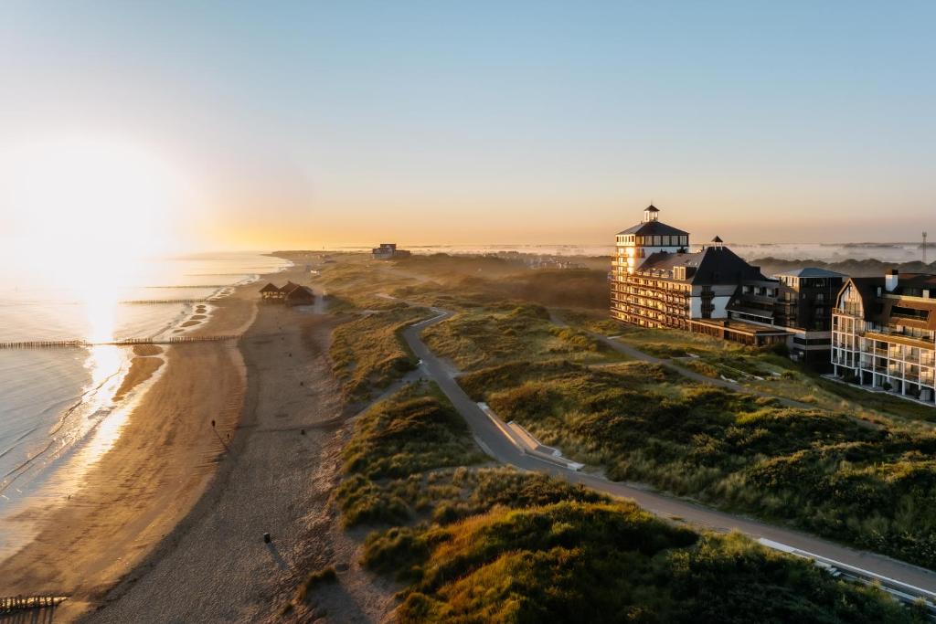 カトザント・バートにあるStrandhotelの夕日時の海とビーチの景色を望めます。