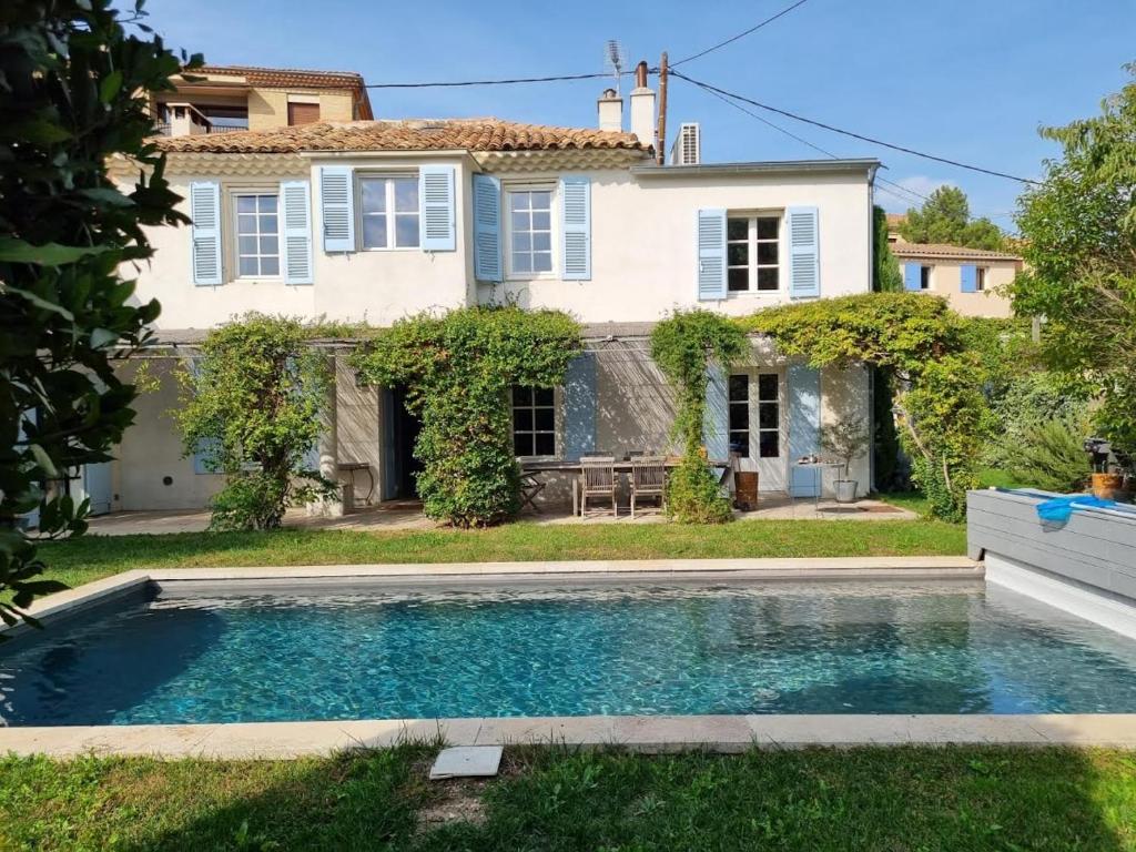 a villa with a swimming pool in front of a house at Maison avec piscine in Aix-en-Provence