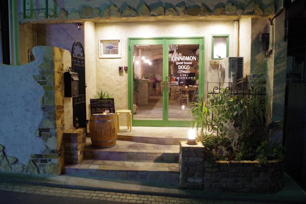 uma porta da frente de um restaurante à noite em Cinnamon Guesthouse Dogo em Matsuyama