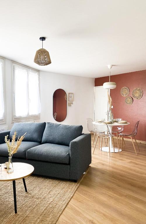 un salon avec un canapé bleu et une table dans l'établissement Le Grand 117 - Climatisation - Wifi - Parking proche, à Périgueux