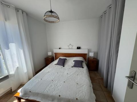 une chambre avec un lit dans une pièce blanche dans l'établissement Hébergement à la campagne, à Évenos