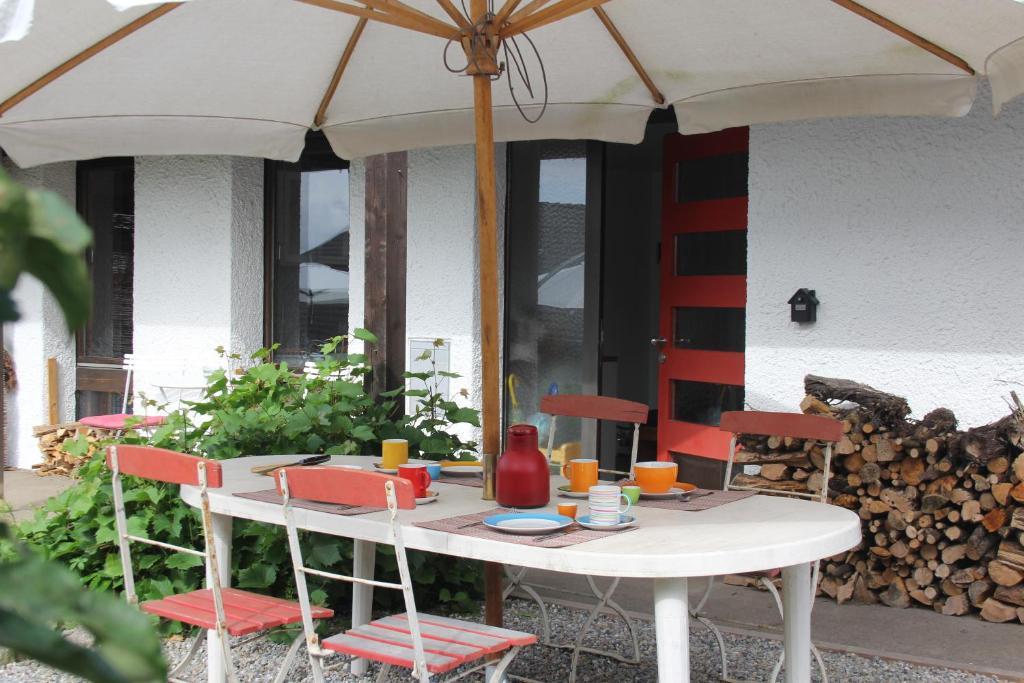 a white table with chairs and an umbrella at Haus Rosebud in Weilheim