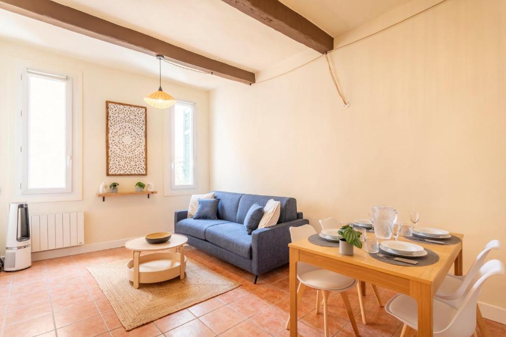 un salon avec un canapé bleu et une table dans l'établissement Le Petit Saint Esprit - Centre Ville - Calme - Lumineux - Fibre, à Aix-en-Provence