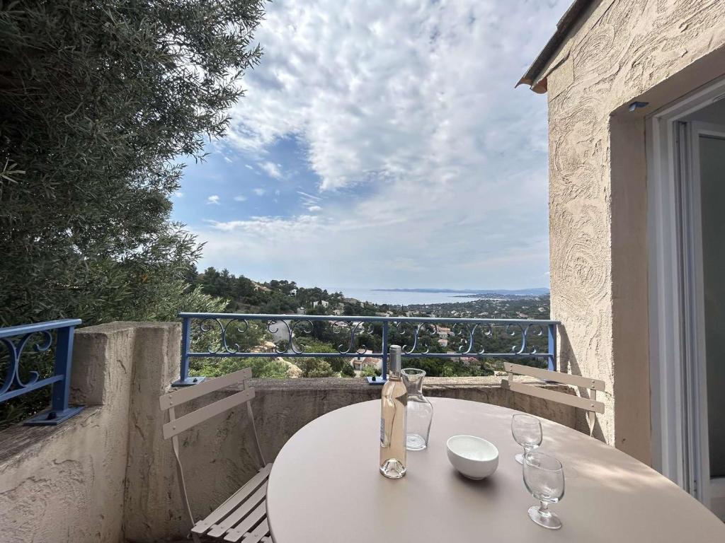 une table blanche avec deux verres sur un balcon dans l'établissement Appartement climatisé 2 pièces avec piscine et parking sécurisé - FR-1-226-524, à Roquebrune-sur Argens