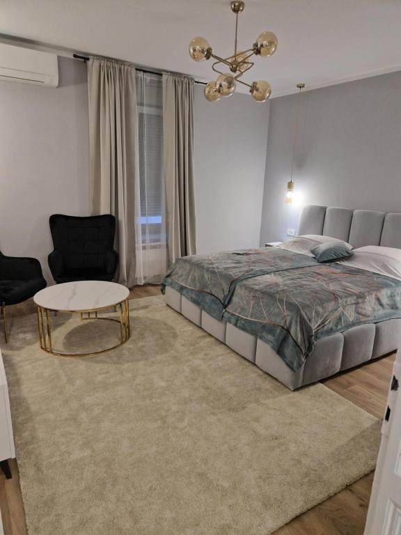een slaapkamer met een bed, een tafel en een stoel bij Luxury Apartment Paper in Zagreb