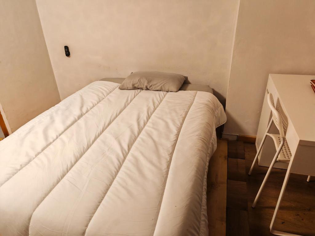 Cama pequeña en habitación pequeña con mesa en Share Home, en Barcelona