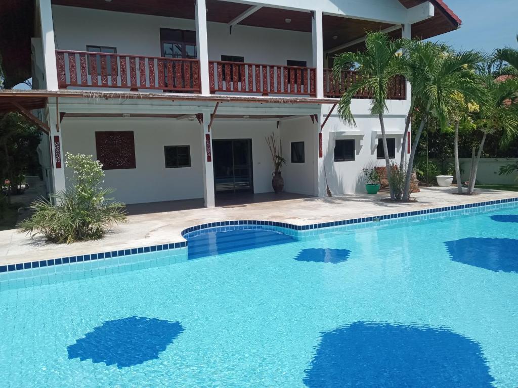a swimming pool in front of a house at Lyndale Lodge in Sam Roi Yot