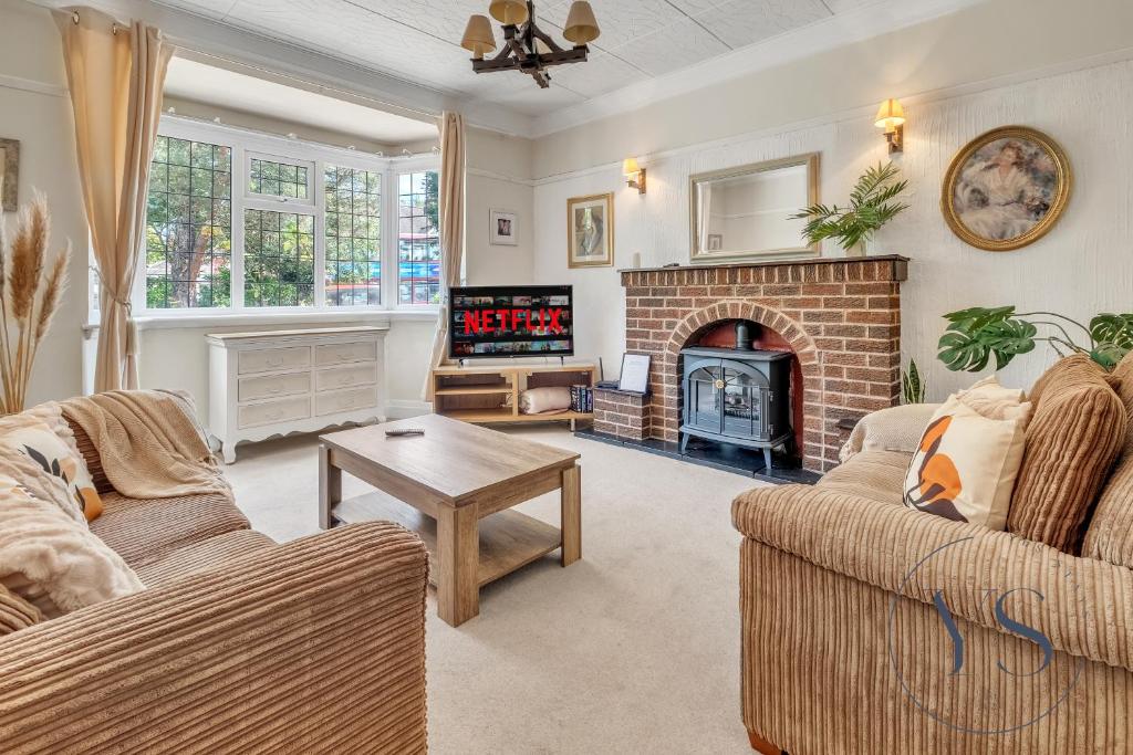 Una sala de estar con dos sofás y una chimenea. en 4BR Cottage, Parking, NEC, Birmingham Airport, en Birmingham