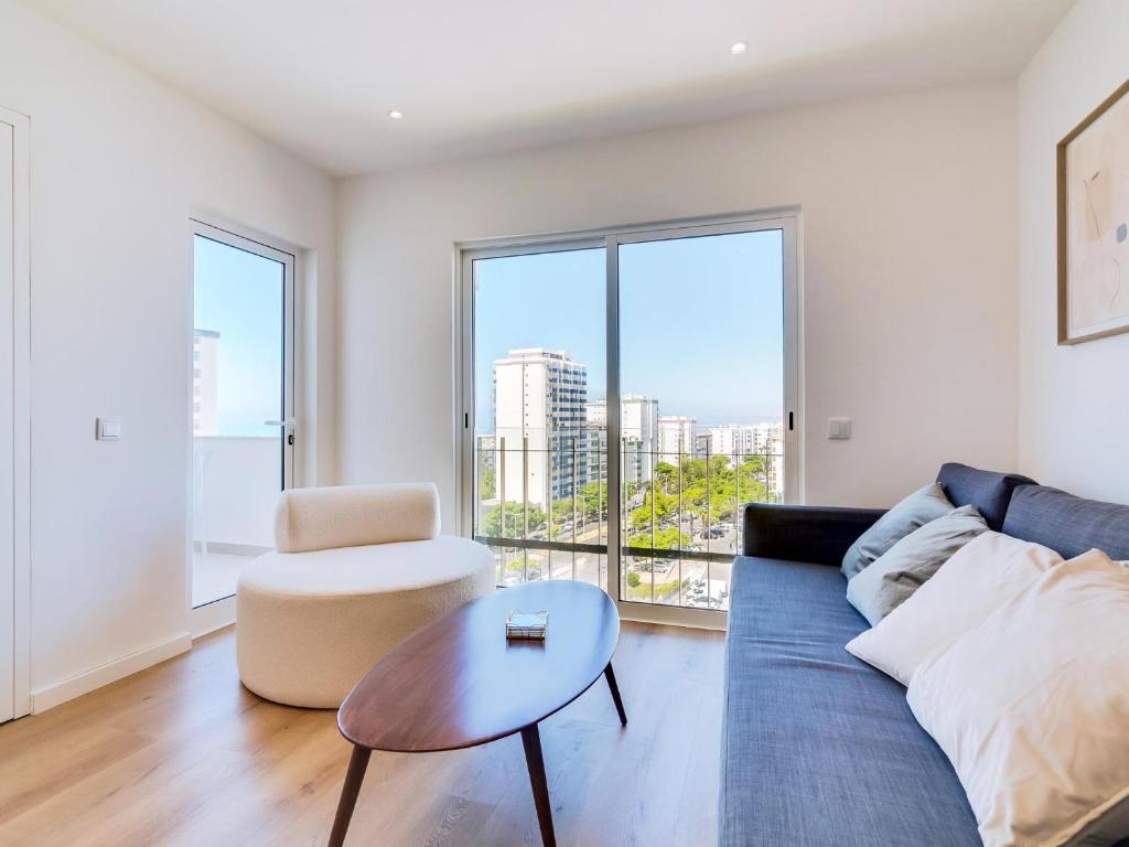 クアルテイラにあるAL Apartamento Alsolの青いソファとテーブルのあるリビングルーム