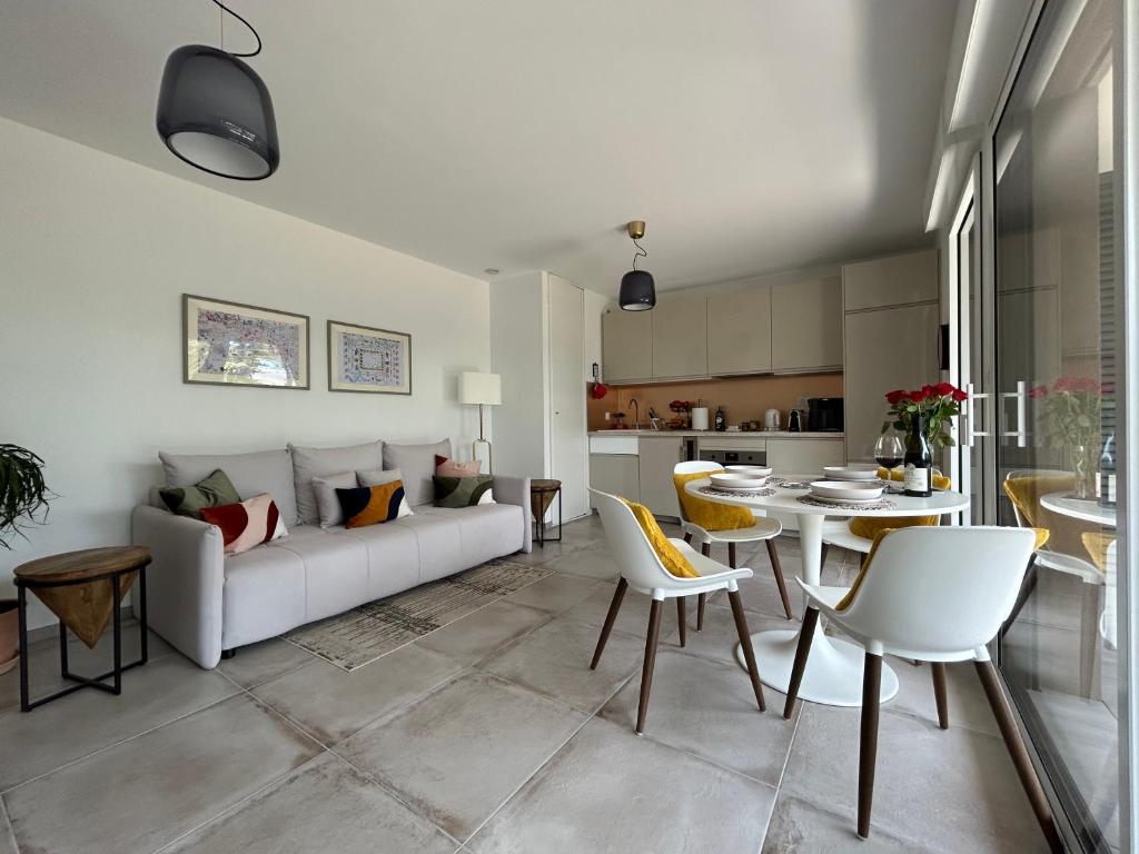 un salon avec un canapé, une table et des chaises dans l'établissement L'Oasis Maritime, à Nice