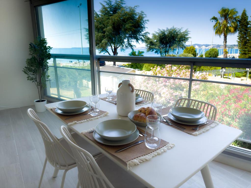 une table blanche avec des chaises et des assiettes de nourriture dans l'établissement By the beach, Sea View, brand new, à Cagnes-sur-Mer