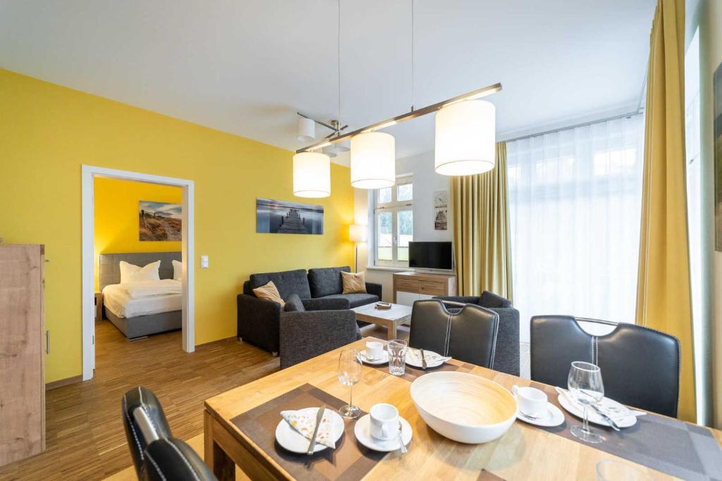 ein Esszimmer und ein Wohnzimmer mit Tisch und Stühlen in der Unterkunft Ferienwohnung "Düne" im Ostsee-Domizil Sandburg in Kühlungsborn