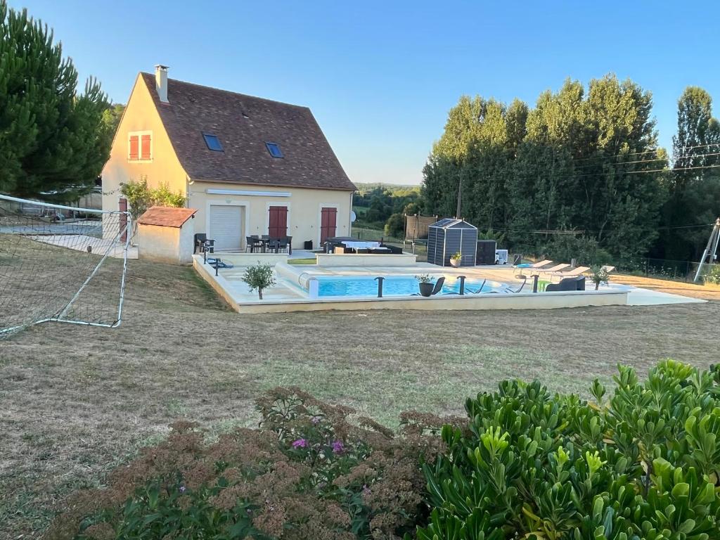 a house with a swimming pool in a yard at Maison 6km de Sarlat piscine chauffée et jacuzzi in Saint-Vincent-le-Paluel