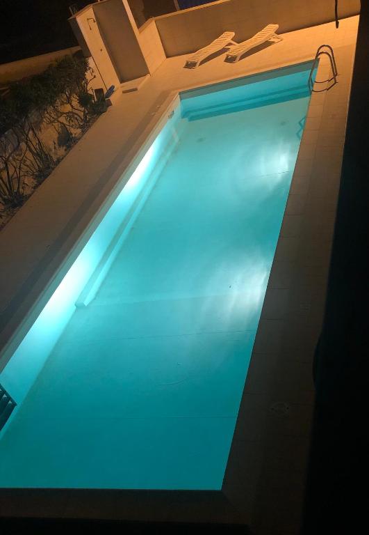 a large swimming pool with a blue light in it at Palese Profumo di Mare in Santo Spirito