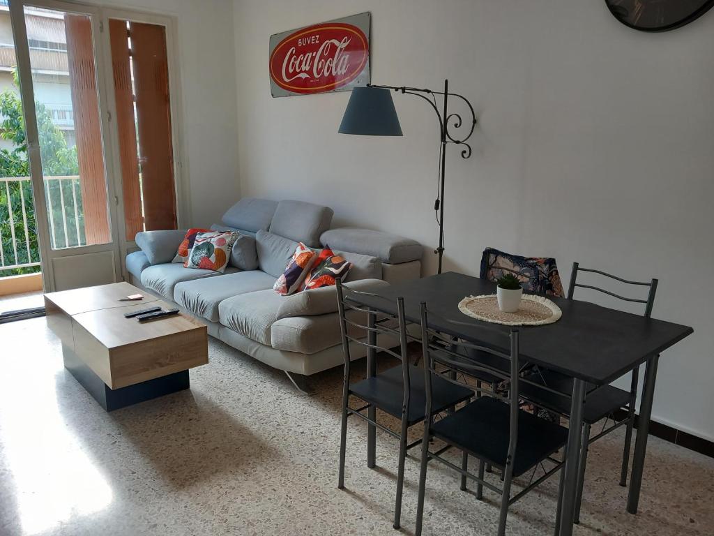 un salon avec un canapé et une table dans l'établissement Appartement cosy Nice, à Nice