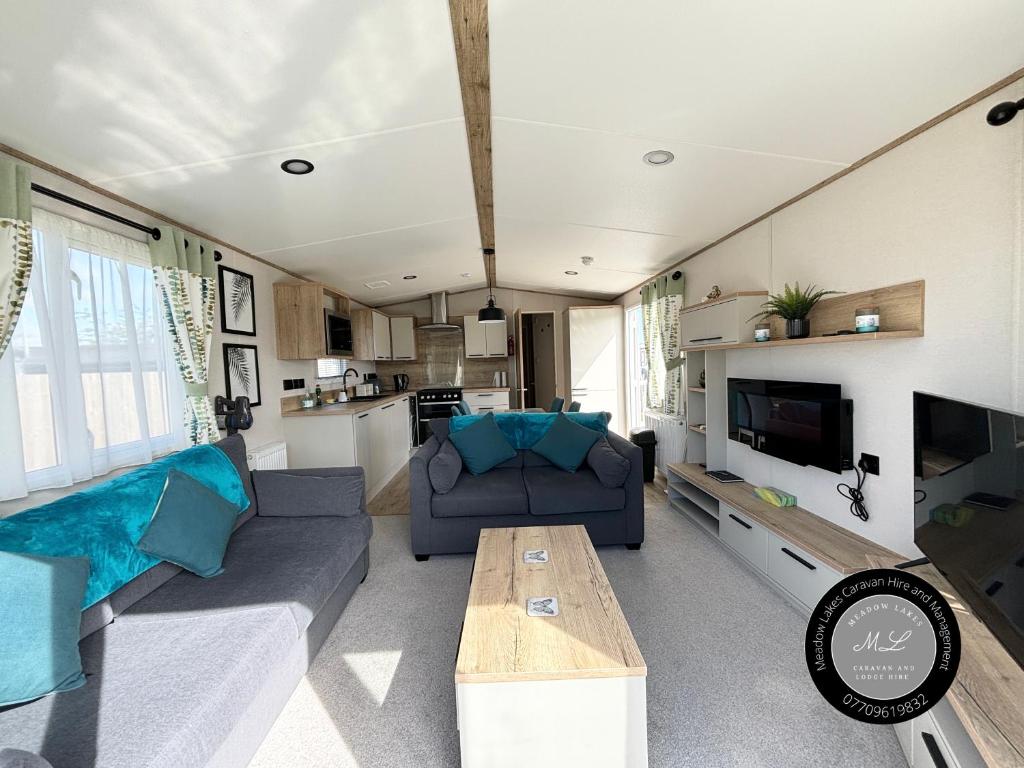 ein Wohnzimmer mit Sofa und Tisch in der Unterkunft The Retreat 16 - pet friendly, WiFi, and a bath - Golden Palm Resort - Meadow Lakes Caravan & Lodge Hire in Chapel Saint Leonards