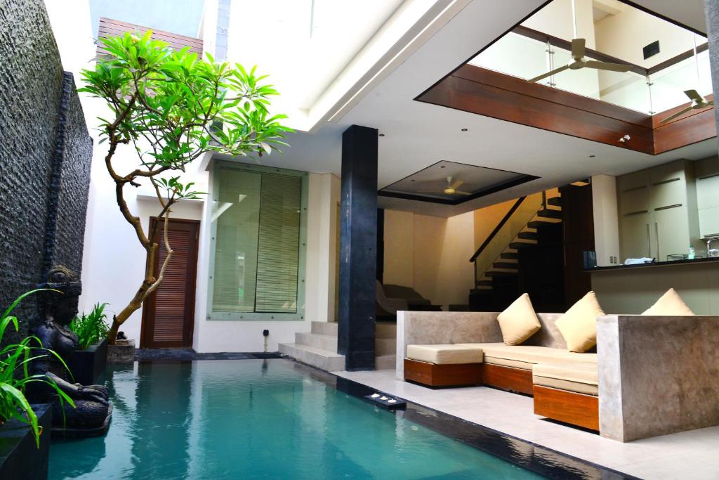 a living room with a swimming pool in a house at Villa Tentrem Legian in Legian