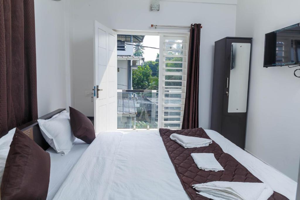 Postel nebo postele na pokoji v ubytování Guest West Inn Cochin